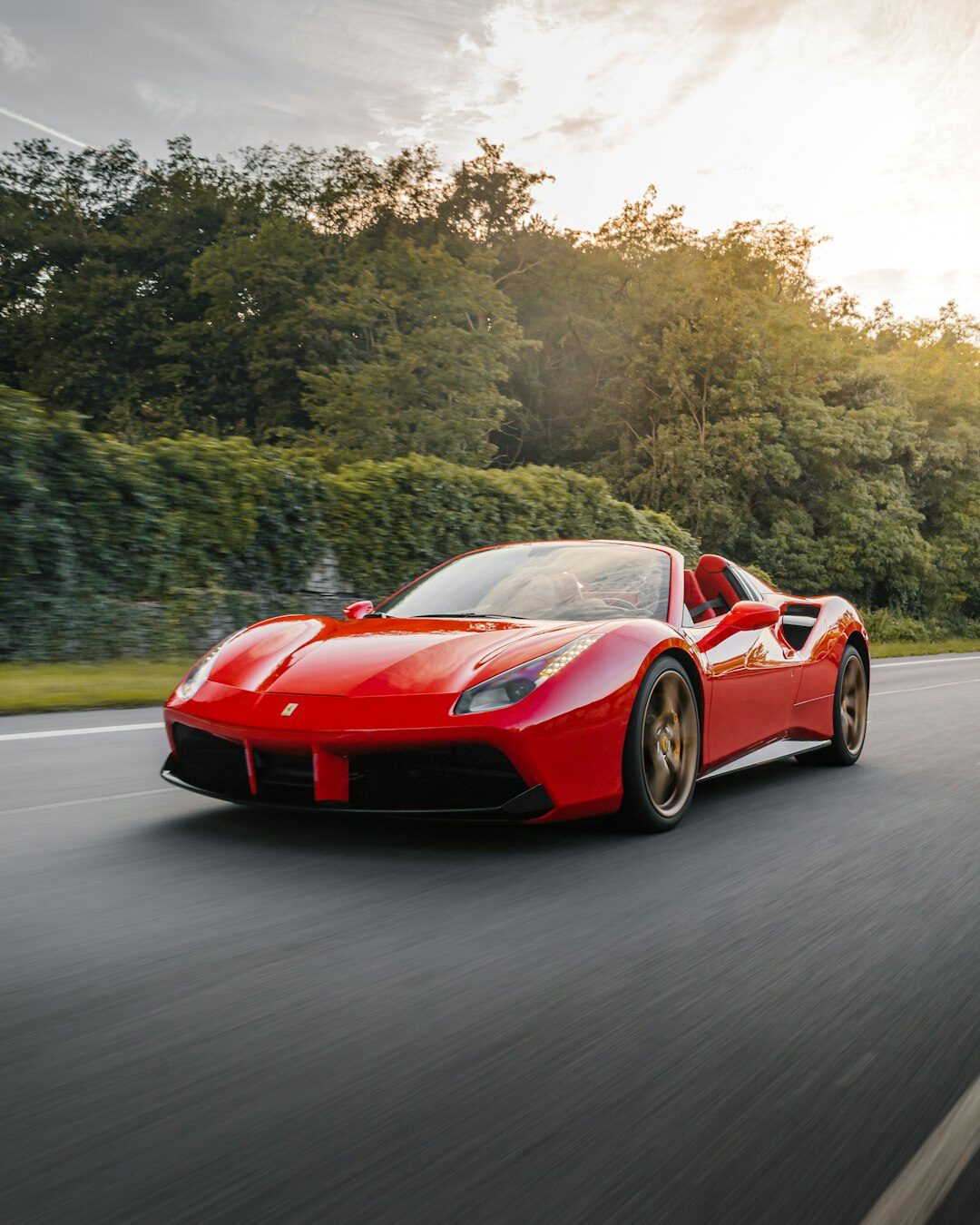 Red Ferrari Portofino convertible sports car on a coastal road